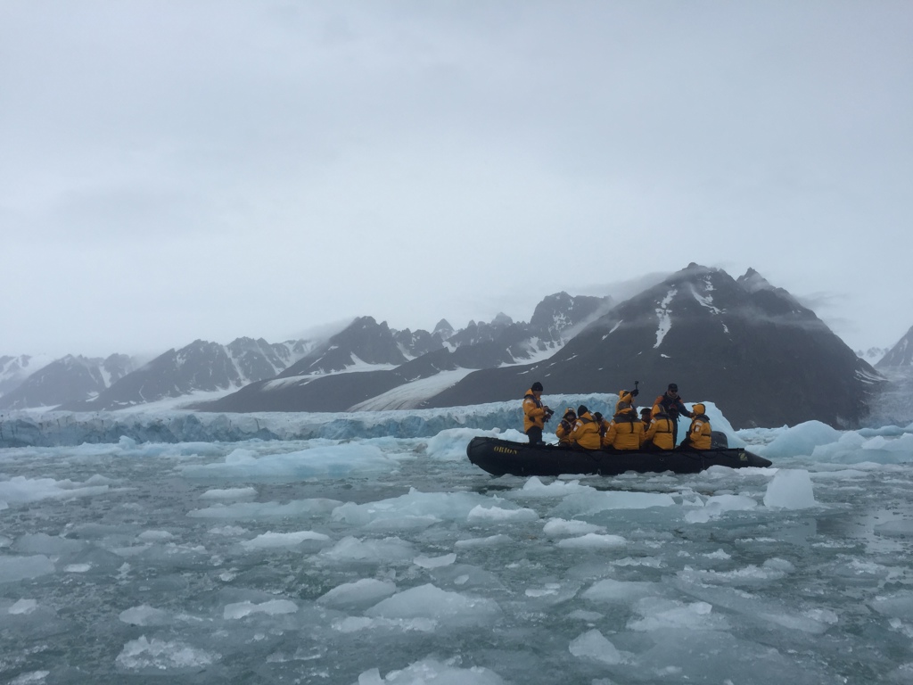 Zodiac met reizigers tussen pakijs en gletsjerbergen bij Spitsbergen tijdens groepsrondreis.