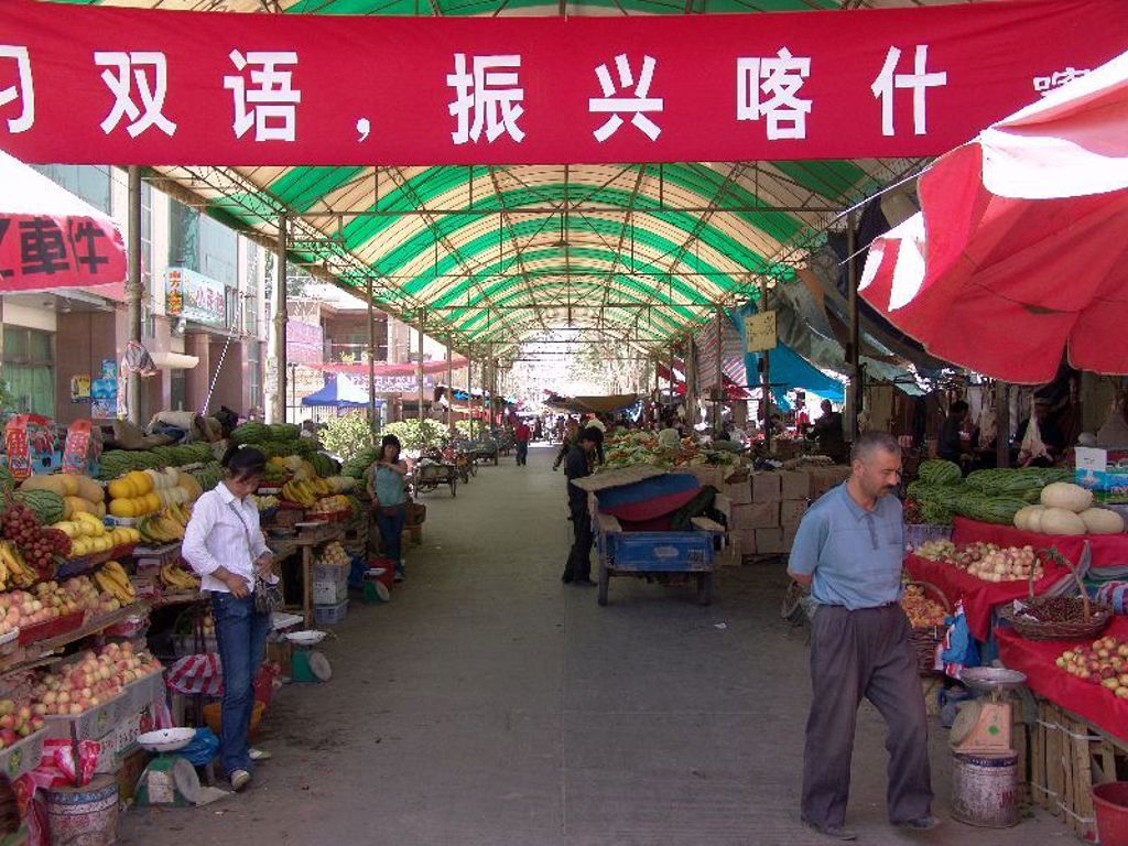 Overdekte markt in China met kraampjes vol groente en fruit, tijdens een familiereis China.