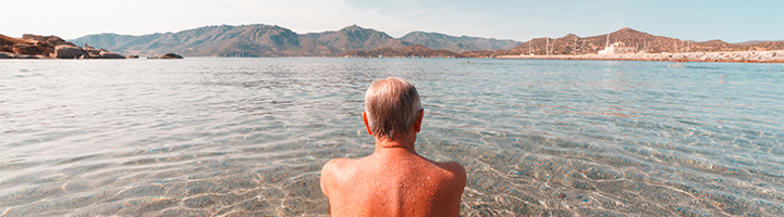 Man kijkt uit over de zee bij Sardinië, een van de Blue Zones bestemmingen van Sawadee.