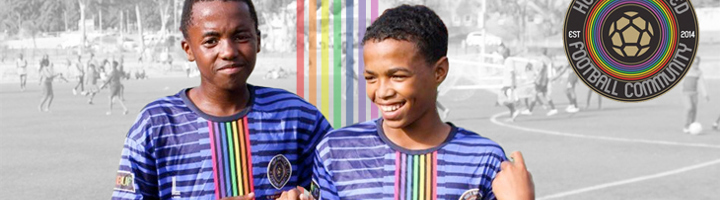 Twee jeugdspelers van Hout Bay United Football Community in clubshirt op het voetbalveld.