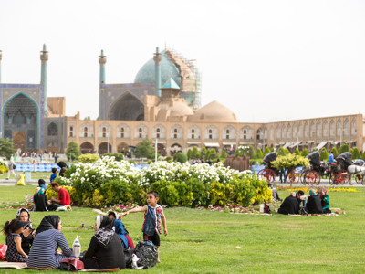 Families picknicken op het Naqsh-e Jahan-plein in Isfahan, met de Imam-moskee op de achtergrond.