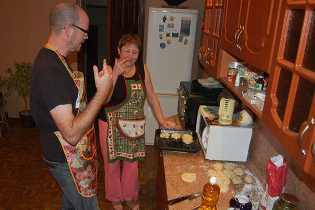 Reizigers bakken koekjes in een keuken tijdens Groepsrondreis Rusland Winter.