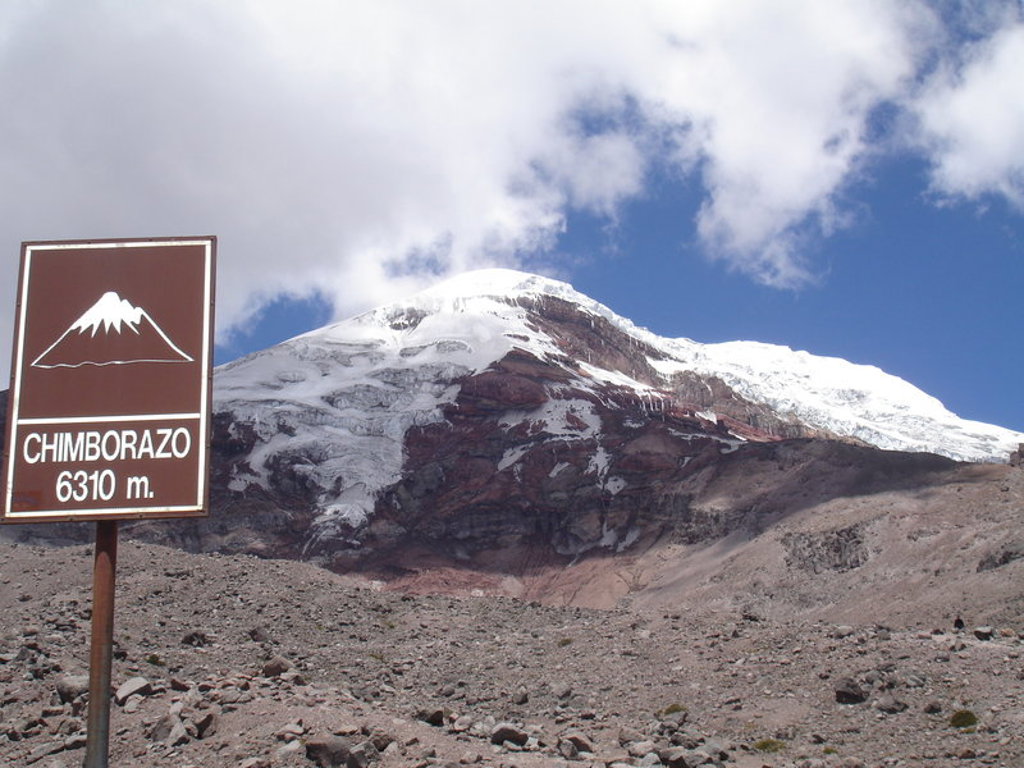 Uitzicht op de besneeuwde Chimborazo-vulkaan in Ecuador, met bord “Chimborazo 6310 m.”.