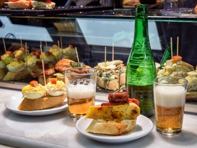 Tapas en pintxos met twee glazen bier op de bar tijdens familiereis Spanje & Portugal.