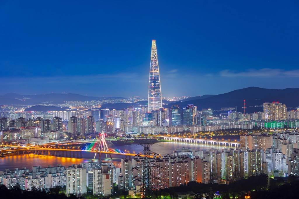 Avondzicht op Seoul met de verlichte Lotte World Tower en een brug over de Han-rivier, Zuid-Korea.
