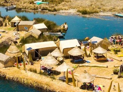 Uitzicht op het Titicacameer in Peru met rietvelden en bergen op de achtergrond.