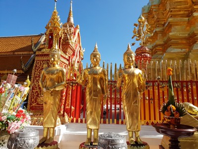 Gouden Boeddhabeelden bij een kleurrijke tempel in Noord-Thailand tijdens de route Thailand Noord en Zuid.