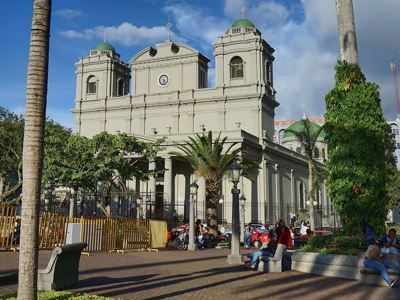 Kathedraal van Managua met groene koepels aan een plein met palmbomen, Nicaragua.