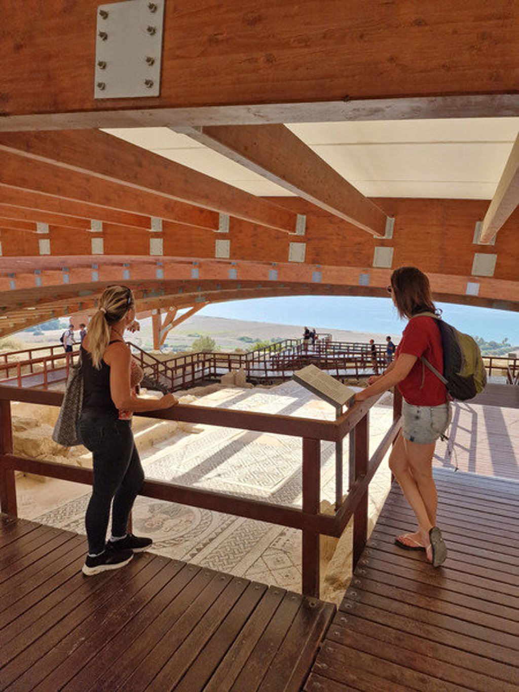 Wandelaars bekijken mozaïeken in een archeologische opgraving op Cyprus tijdens een wandelvakantie.