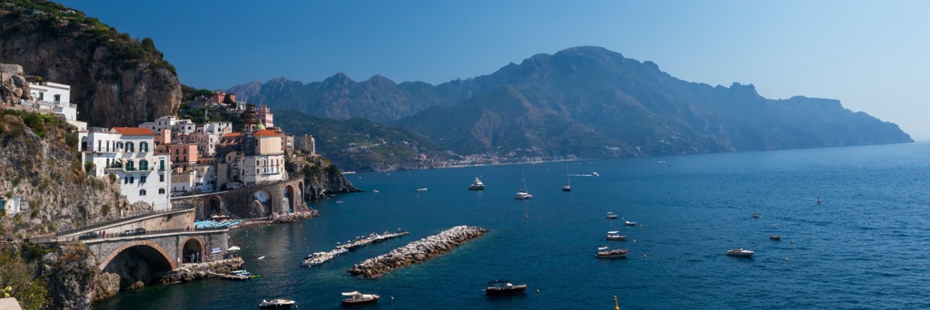 Kustdorp aan de Amalfikust in Italië met kliffen, pastelhuizen en boten op zee.