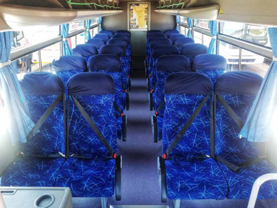 Interieur van een comfortabele touringcar met blauwe stoelen voor vervoer in Zuidelijk Afrika.