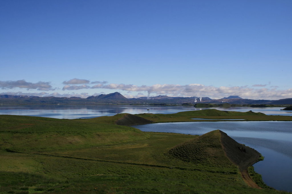 Groene heuvels en merenlandschap in IJsland met bergen op de achtergrond tijdens een groepsrondreis IJsland.