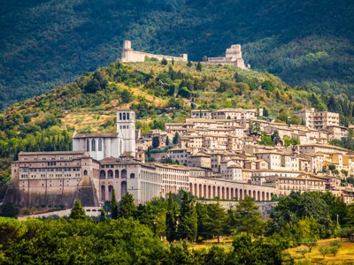 Assisi met de basiliek van Sint-Franciscus en de Rocca Maggiore, uitzicht op de groene heuvels van de Apennijnen.