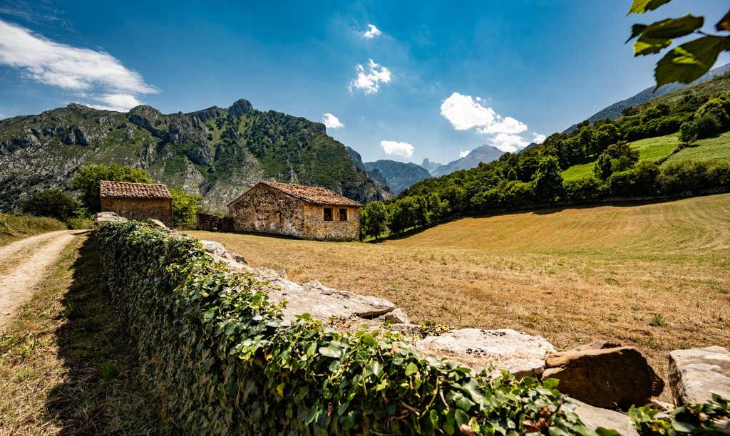 Landelijke boerderijen met akkers en bergtoppen in de Picos de Europa, Spanje.