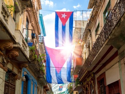 Cubaanse vlaggen hangen boven een straat met historische gevels en balkons in Havana, Route Cuba .