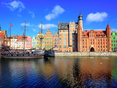 Gdańsk aan de Motława met kleurrijke gevels, de Kraanpoort en een historisch schip in de haven.