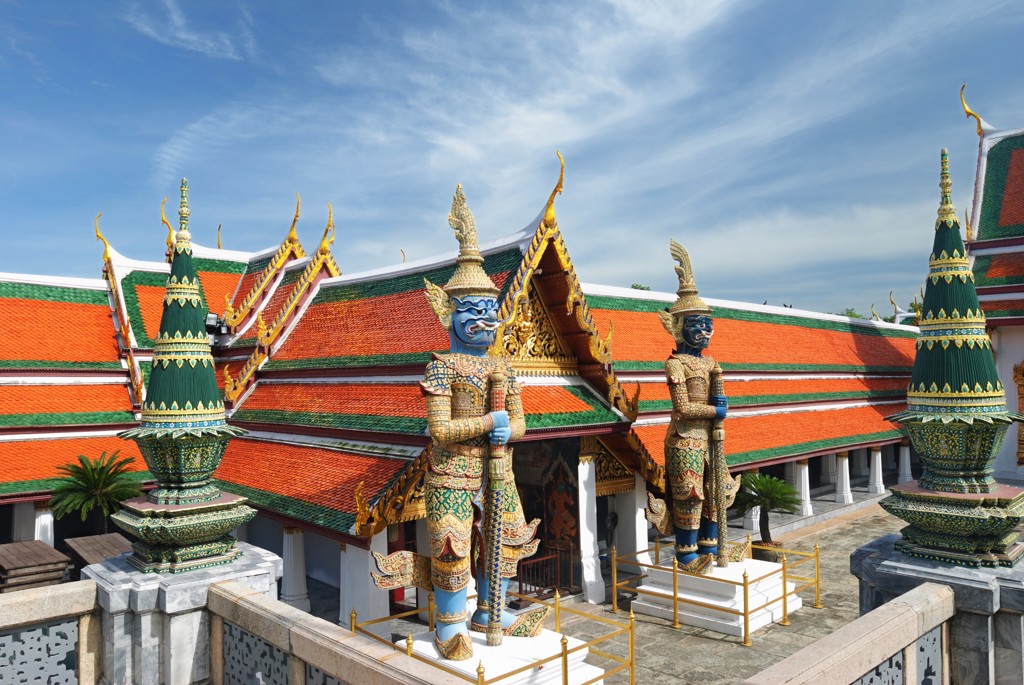Tempelcomplex in Thailand met kleurrijke daken en reuzenwachters, tijdens fietsvakantie Vietnam, Cambodja & Thailand.