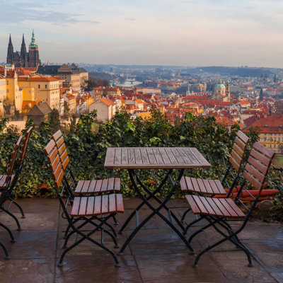 Uitzicht over Praag met terrastafels en de Sint-Vituskathedraal, startpunt van de fietsvakantie van Praag naar Wenen.