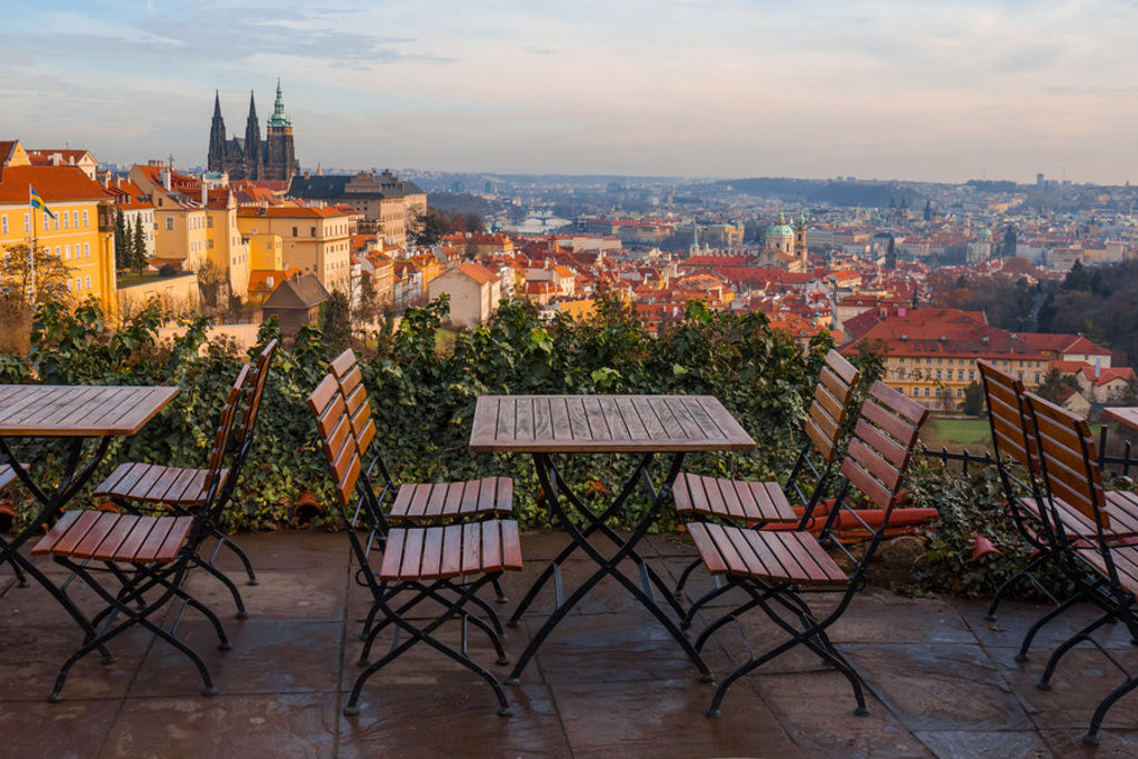Uitzicht over Praag met terrastafels en de Sint-Vituskathedraal, startpunt van de fietsvakantie van Praag naar Wenen.