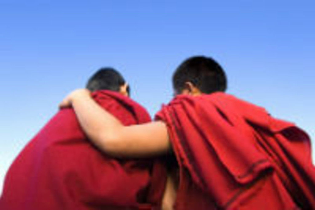 Twee boeddhistische monniken in rode gewaden met arm om elkaars schouder, Myanmar.