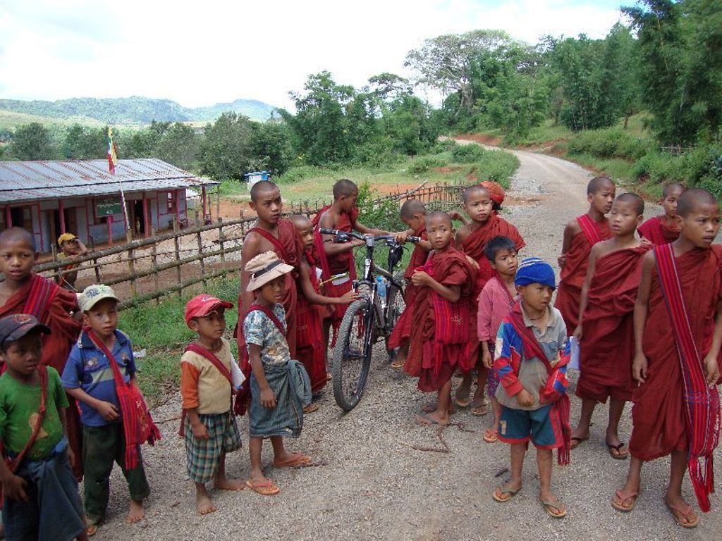 Jonge monniken en kinderen langs een landelijke weg in Myanmar tijdens een familiereis.