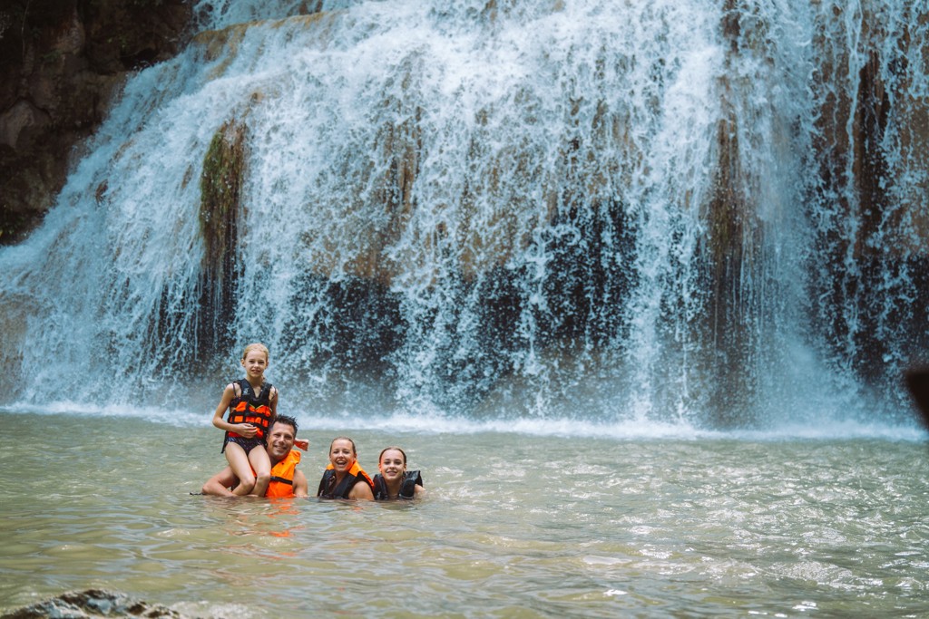 Gezin zwemt bij een waterval tijdens familiereis Thailand Noord en Zuid.