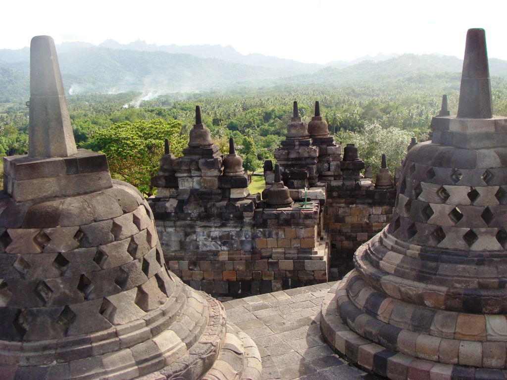 Stupa’s van de Borobudur-tempel op Java met uitzicht over groene jungle en bergen tijdens groepsrondreis Java & Bali.