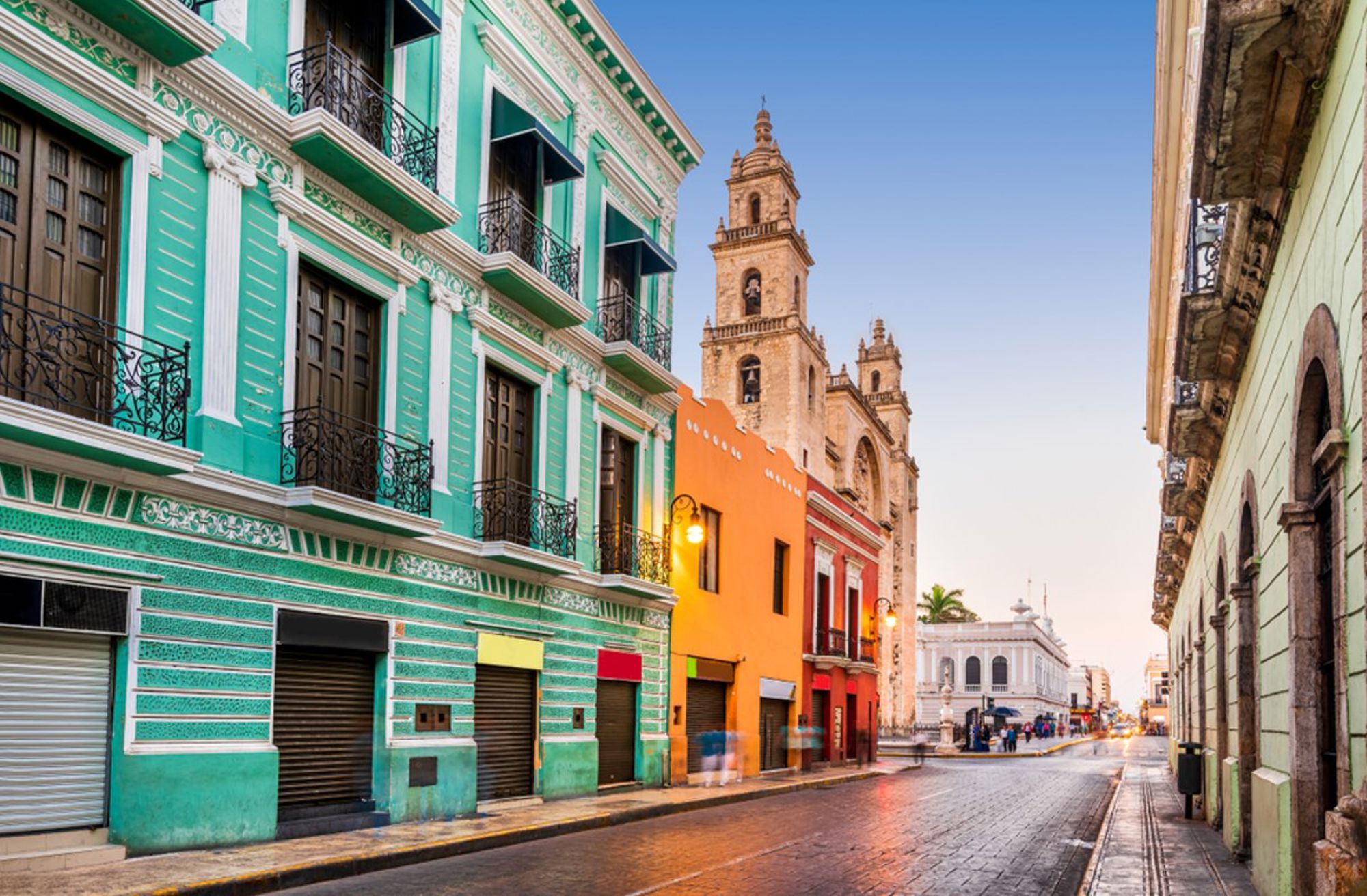 Kleurrijke straat in het historische centrum van Mérida, Mexico, met de kathedraal op de achtergrond.