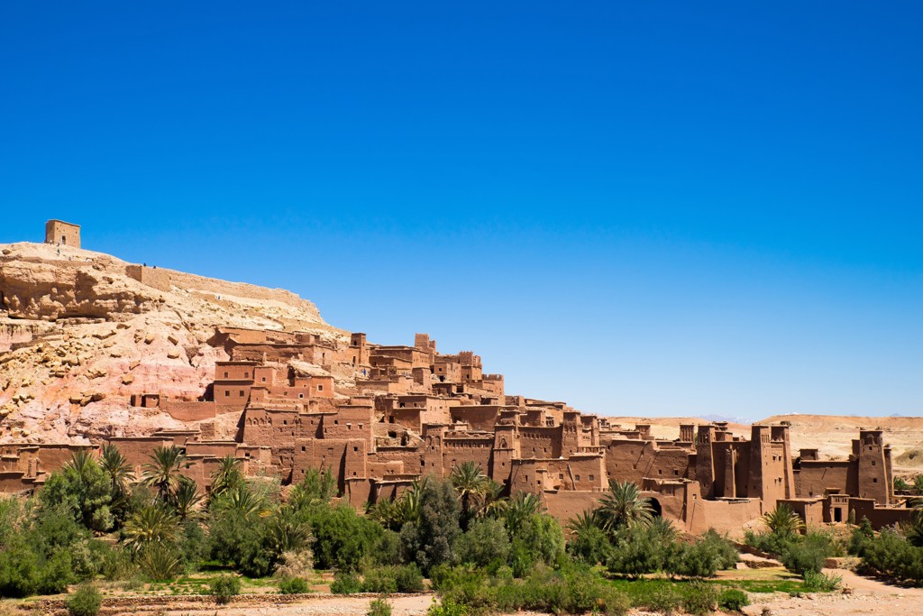Kasbah Aït Ben Haddou in Marokko, met lemen huizen tegen de heuvel onder een strakblauwe lucht.