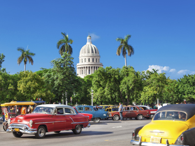 Oldtimers op straat in Havana met het Capitool (El Capitolio) op de achtergrond.