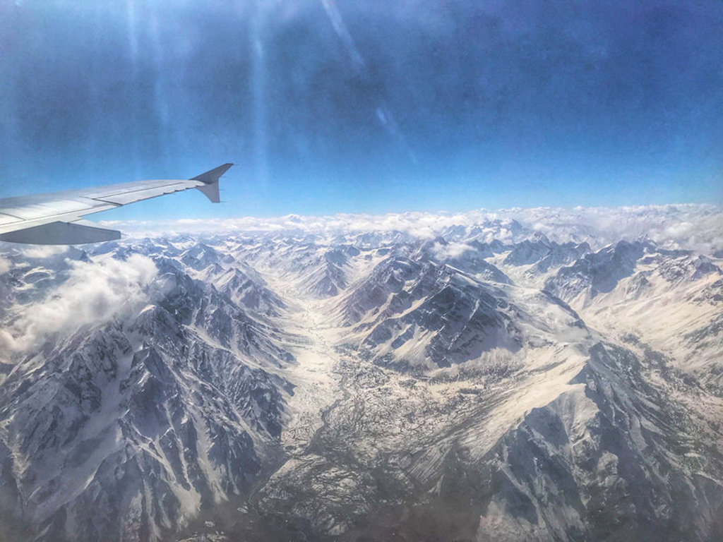 Vliegtuigvleugel boven de besneeuwde bergtoppen van Baltistan en Hunza in Pakistan.