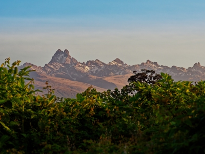 Uitzicht op de ruige toppen van Mount Kenya boven groene begroeiing in Kenia.