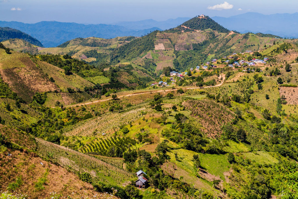Groene heuvels met terrassen en bergdorp in Myanmar, panorama tijdens groepsrondreis Myanmar Hoogtepunten.