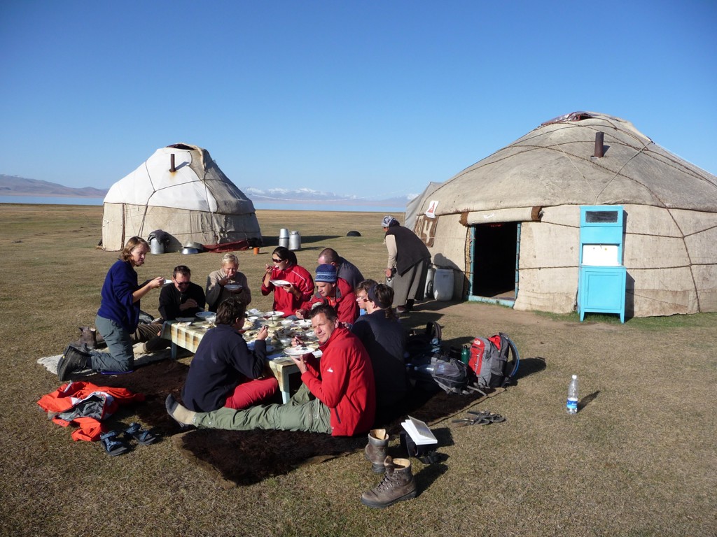Groepsrondreis Zijderoute: reizigers lunchen bij yurts op de steppe.
