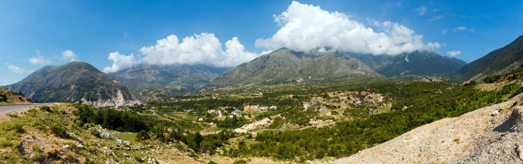 Panoramisch uitzicht op een groene vallei met bergen en wolken in Albanië tijdens een 22-35ers reis.