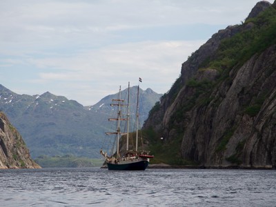 Zeilschip in een fjord tussen steile rotswanden op de Lofoten, Noorwegen.