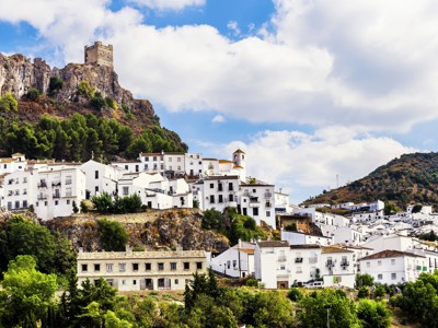 Witte huizen van het Andalusische dorp Zahara de la Sierra met kasteel op de rots.