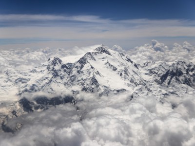 Besneeuwde bergtoppen in Baltistan en Hunza, Pakistan, boven een wolkendek.
