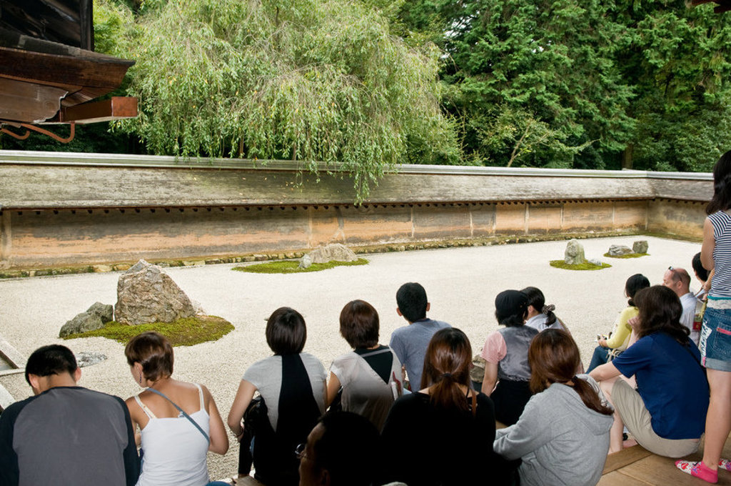 Bezoekers bekijken een zenrotstuin bij een Japanse tempel tijdens een groepsrondreis Japan Hoogtepunten.