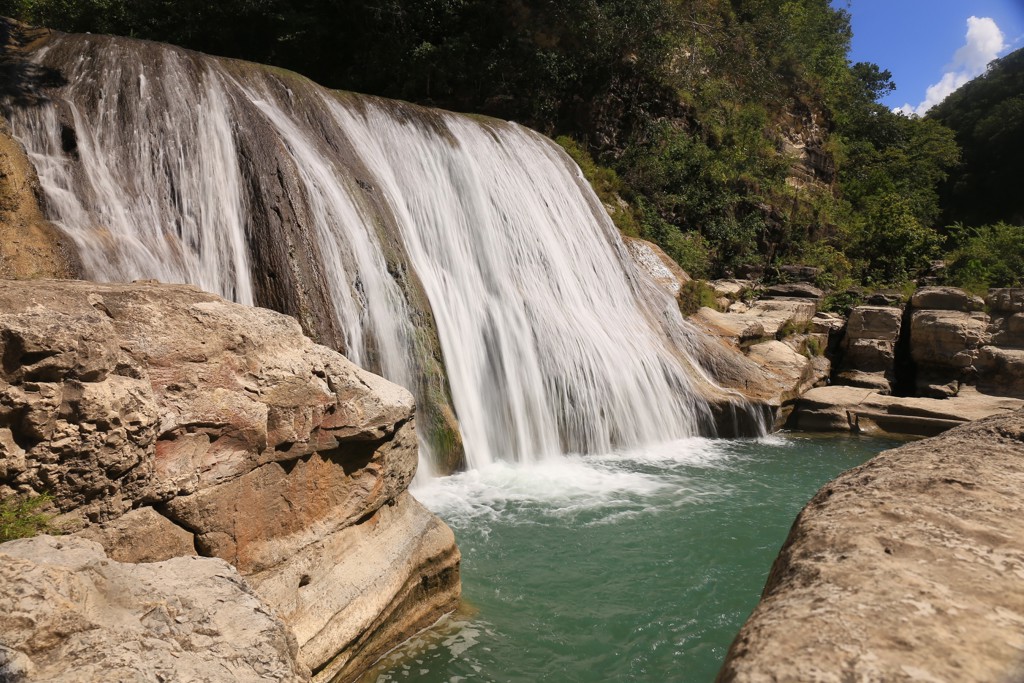 Waterval met turquoise poel tussen rotsen tijdens rondreis Timor, Sumba & Bali.