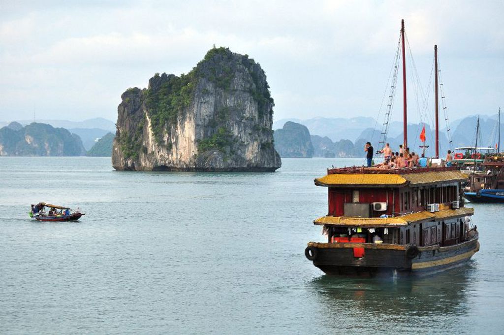 Cruiseboot in Halong Bay, Vietnam, langs kalkstenen rotsen tijdens groepsrondreis Vietnam kort.