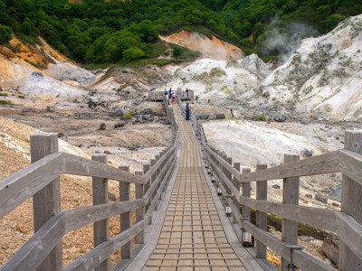 Houten wandelpad door een dampend vulkanisch landschap in Japan tijdens de Route Japan 21 dagen.