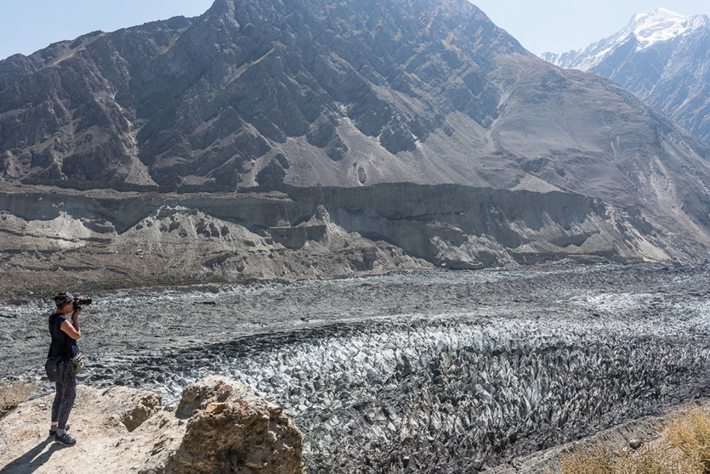Reiziger fotografeert de Passu-gletsjer in de Hunza-vallei, Pakistan, met ruige bergtoppen op de achtergrond.