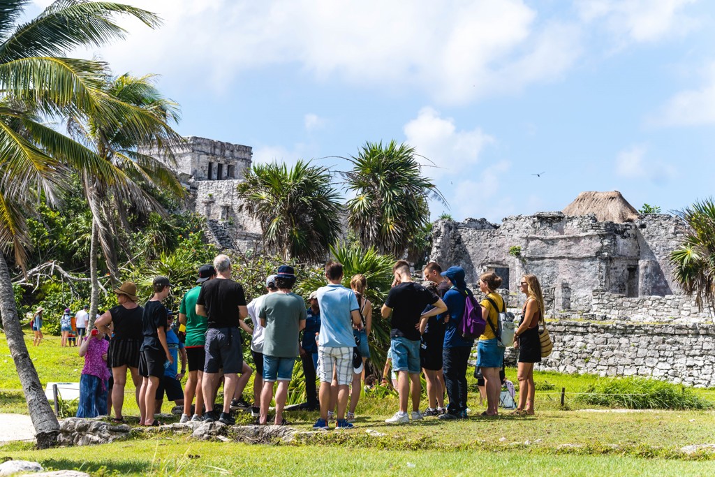 Groep reizigers bij de Maya-ruïnes van Tulum aan de kust van Mexico tijdens een familiereis.