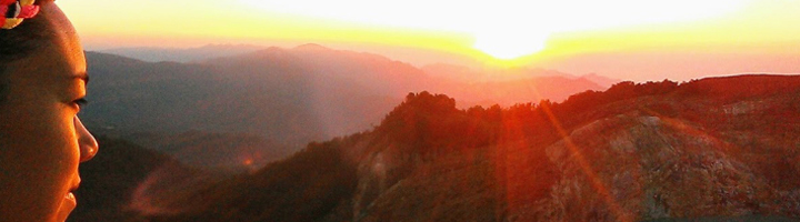 Reiziger kijkt bij zonsopgang uit over berglandschap in Indonesië.