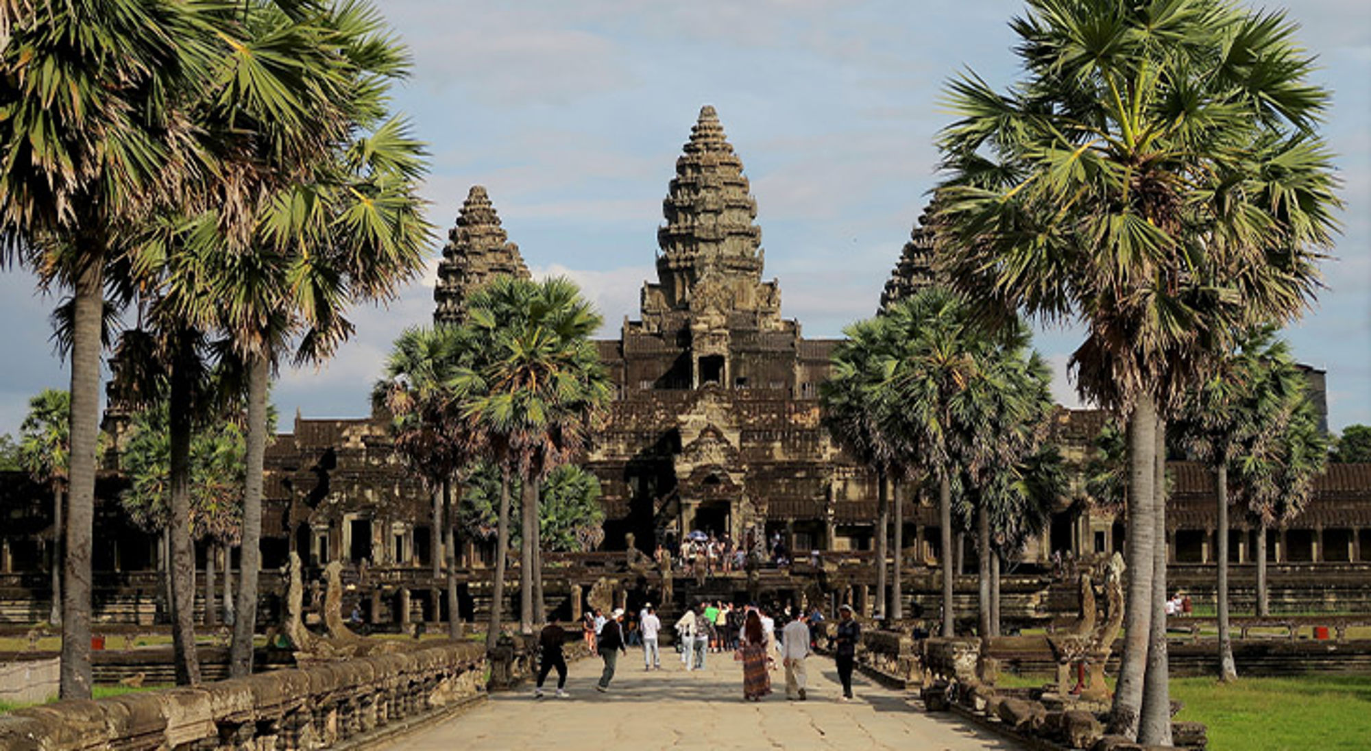 Bergdorpje Noord-Laos Hoofdingang van Angkor Wat met palmbomen en bezoekers op de toegangsweg.