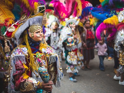 Gemaskerde dansers in kleurrijke kostuums tijdens een straatfestival in Guatemala.