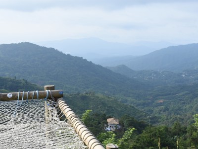 Uitzichtpunt met hangnet en panorama over groene bergvalleien in Colombia.