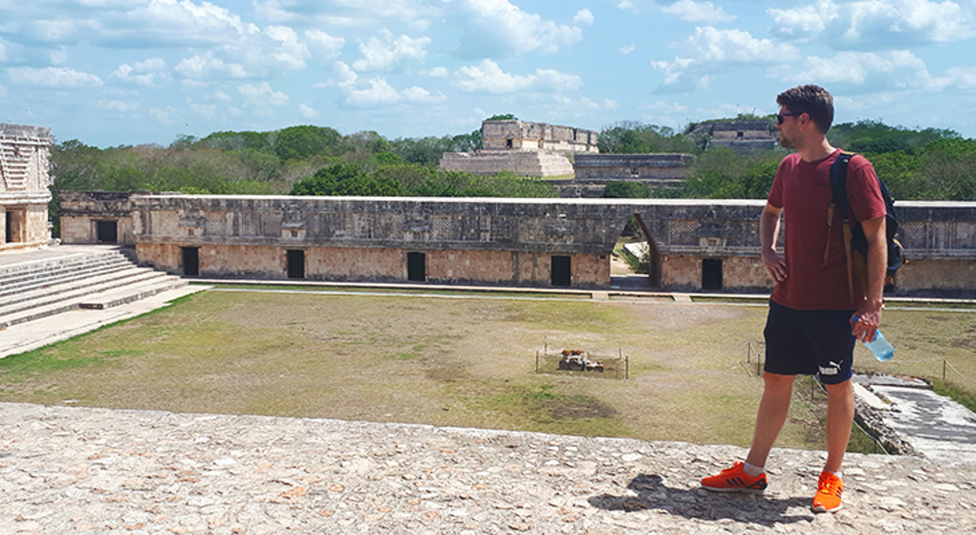 Toerist met rugzak kijkt uit over de archeologische ruïnes van Uxmal in Yucatán, Mexico.