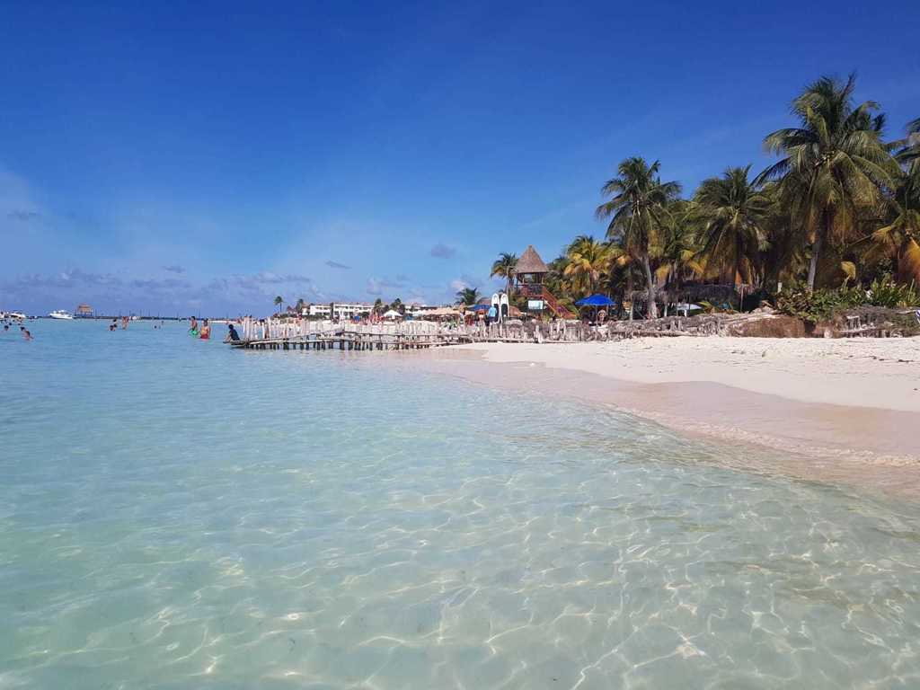 Tropisch strand met palmbomen en helderblauw water tijdens een 22-35ers reis door Mexico.
